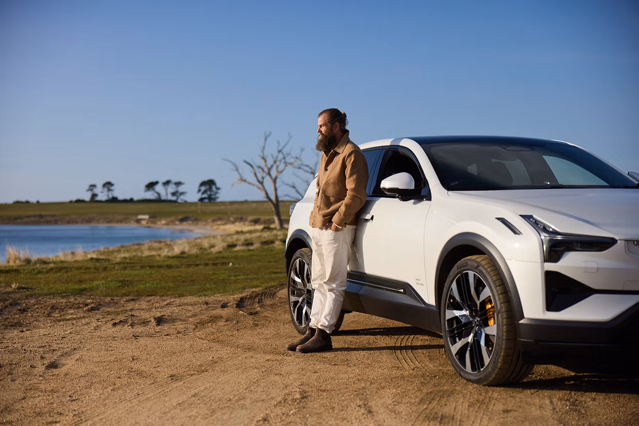 Man leaning on Polestar 3 overlooking ocean