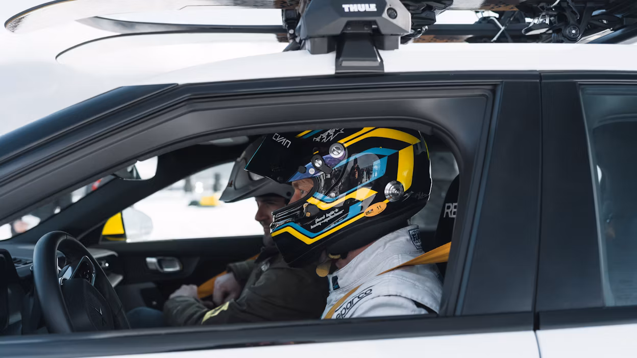 Racing driver wearing helmet sits inside car