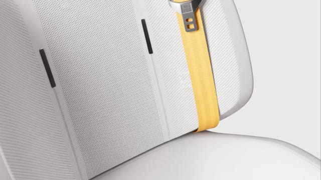 A close up of Polestar 6’s seat with white upholstery and Swedish Gold safety belt.