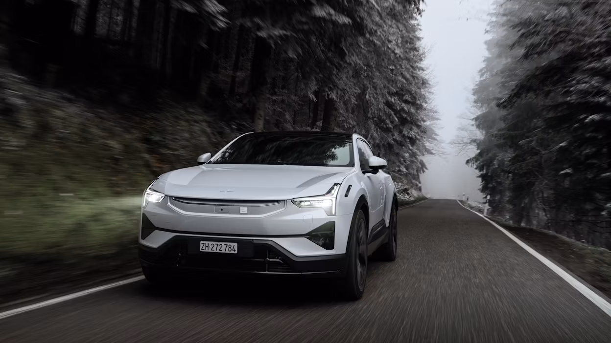 Polestar 3 driving down snowy tree-lined road